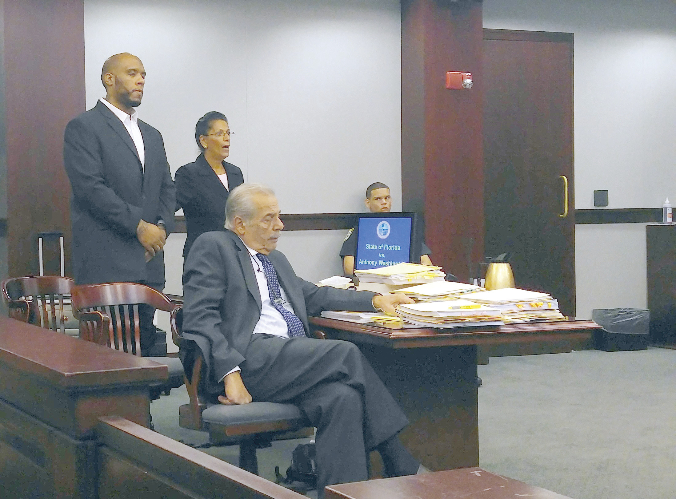 Defendant Anthony Washington (left) stands in court alongside his attorneys, Janis Warren and Tom Fallis.